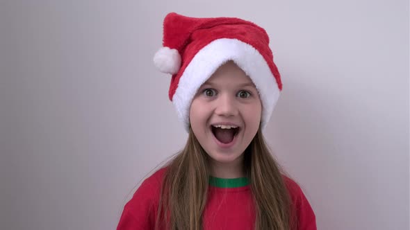 Surprised Christmas Girl in Santa Hat on White Background