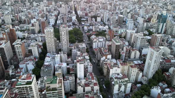 Aerial lowering over Belgrano neoghborhood buildings at sunset with bright sun in horizon, Buenos Ai