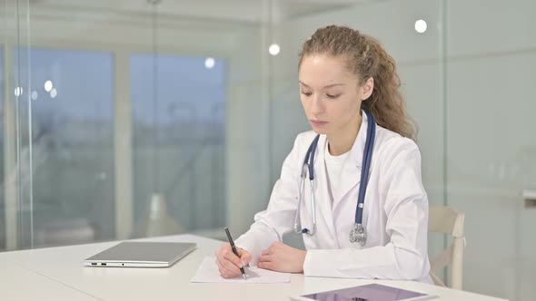 Focused Young Doctor Doing Paperwork in Modern Office 