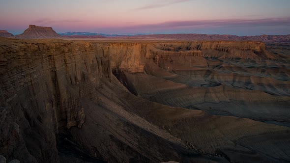 Sunrise time lapse lighting up Factory Butte and cliffs