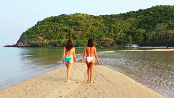 Young Smiling Girls on Photoshoot in The Sun at The Beach on Paradise White Sand and Blue