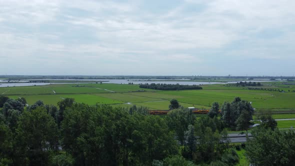 Aerial reveal shot of traffic, fields and Kagerplassen in South Holland, the Netherlands