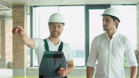 Two Architects are Walking Along the Building in Progress