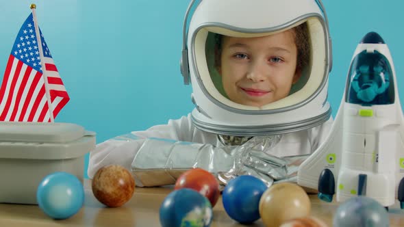 Portrait of a Child Playing at Home in an Astronaut Little Girl 89 Years Old in an Astronaut Costume