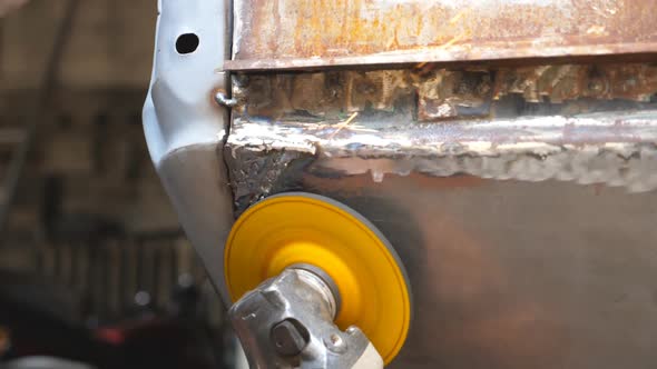 Close Up Arms of Welder Polishing Auto with Electric Professional Equipment in Workshop