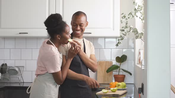 Beautiful Young Couple Preparing Food in Kitchen