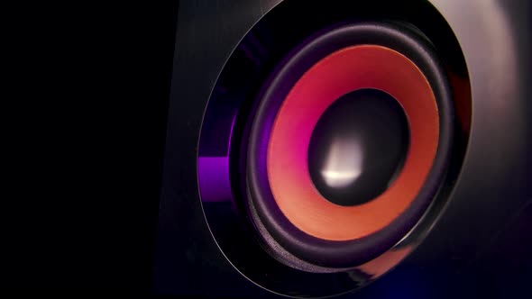 Macro Close Up of Black Vibrating Membranes Loud Sound Speaker in Colorful Neon Lighting