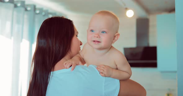 Mom is Holding Her Baby in Her Arms