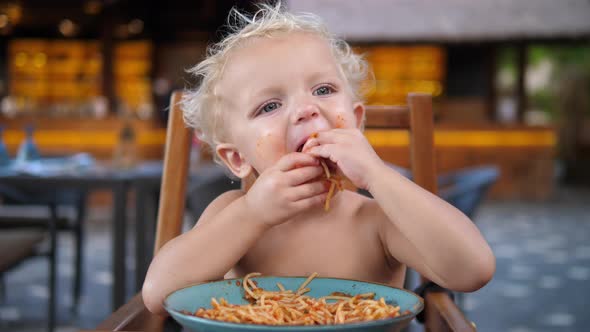 White 2 Year Old Baby Eats Tomato Pasta with Hands