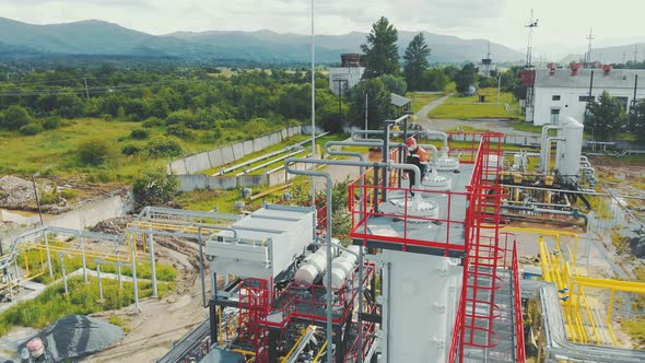 Aerial View Gas Station Operator Climbs To the Top of the Station. Modern Gas Complex in the