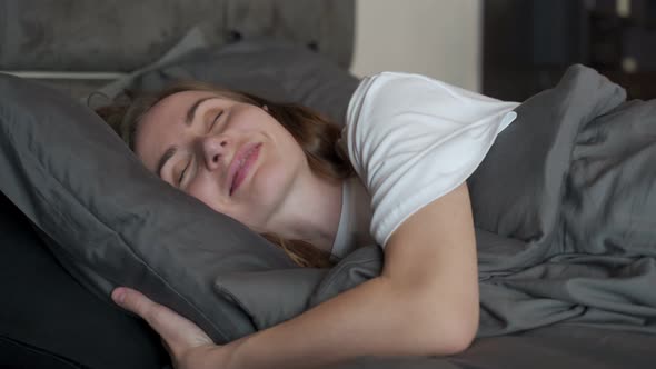 Relaxed Woman in the Bedroom Has Pleasant Dreams Keeps Her Eyes Closed Enjoys a Good Rest at Home