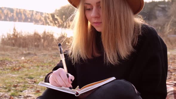 Millennial Woman Slow Motion Caucasian Blonde Woman with Beige Hat in Black Sweater Write on