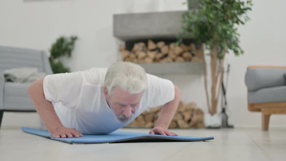 Close Up of Old Man Doing Pushups on Yoga Mat at Home