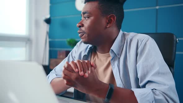 African American Man Looking at Laptop Frustrated After Failing Online Interview