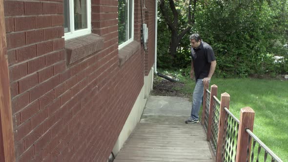 Man walking up home ramp with a limp.