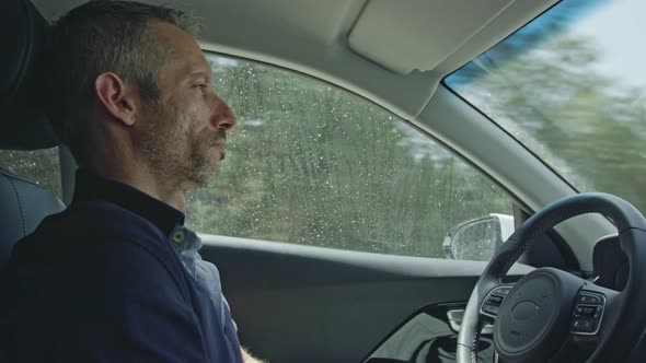 Male driver sitting in an autonomous car, letting the car drive by itself