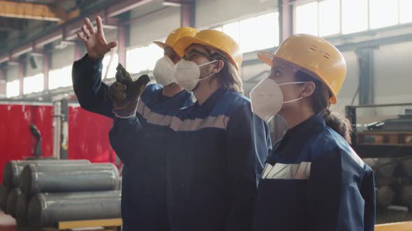 Male Supervisor Explaining New Workers What To Do At Plant Facility