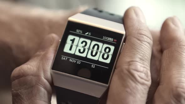 Man Checking His Heart Rate Using a Smart Wristwatch on a Blurred Out Background