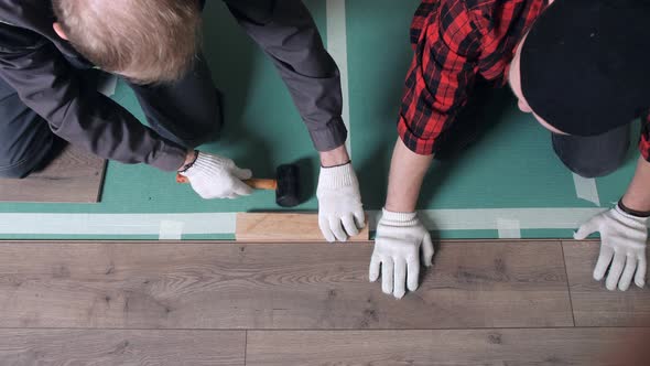 Workers Lays Laminate Flooring in the Apartment