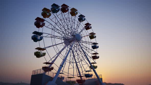 Fun Ferris wheel amusement ride loopable carousel attraction Carnival sunset. 4K