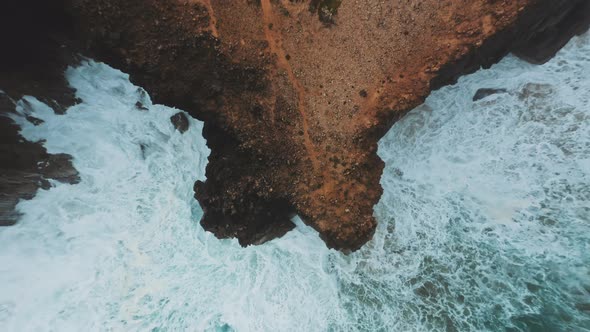 Drone zooming out above ocean coastal caves