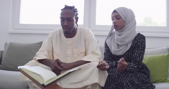 African Muslim Couple at Home in Ramadan Reading Quran Holly Islam Book