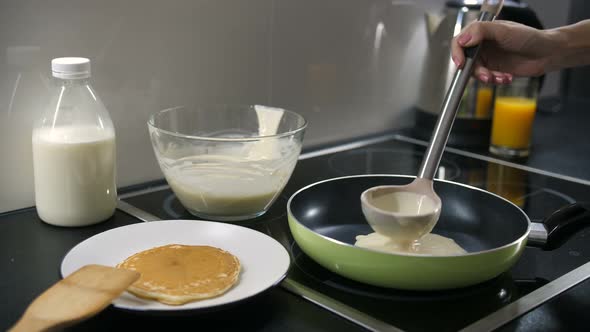 Hand Pouring Pancake Batter Into the Pan