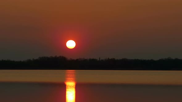 Colour Sunset Over The River With Sun And Orange Clouds