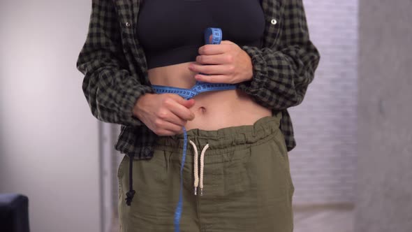 Overweight Woman Measuring Her Waist Size