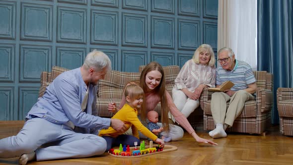 Happy Family Leisure at Home Child Daughter Playing with Mother and Father Railway Toy Game on Floor