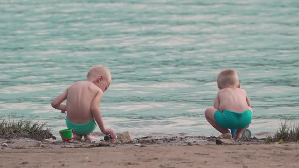 Two caucasian boys play on the seashore during the holidays.