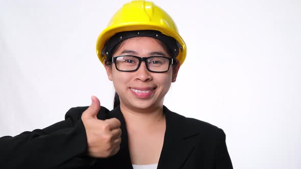 Woman technician smiling with helmet and showing thumbs up.