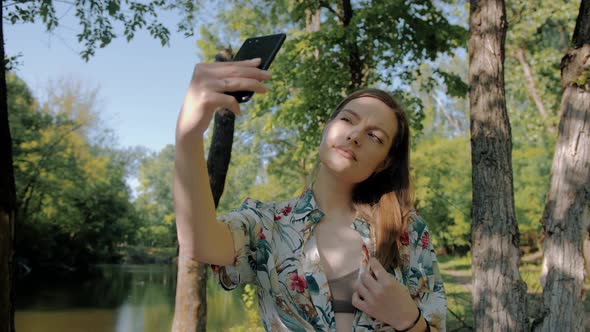 Middle shot of a young beautiful girl who takes a selfie