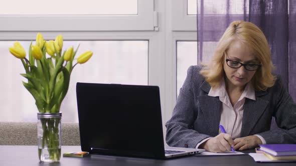 Senior Businesswoman Typing on Laptop at Office