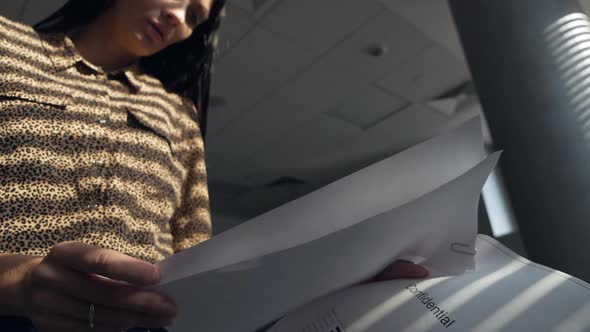 An Undercover Spy Woman Examines Confidential Documents