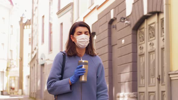 Woman in Medical Mask with Tumbler Walking in City