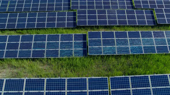 Hundreds of Solar Panels Arranged in Rows on Wild Field