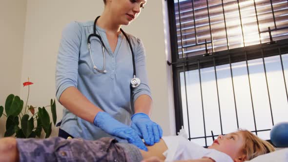 Physiotherapist giving stomach massage to girl patient