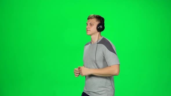 Handsome Guy in Big Headphones Is Running, Chroma Key. Slow Motion