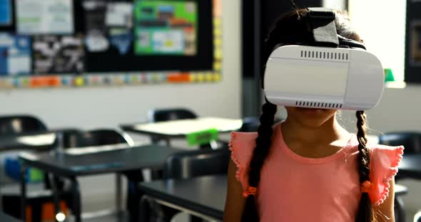 Schoolgirl using virtual reality headset in classroom 4k