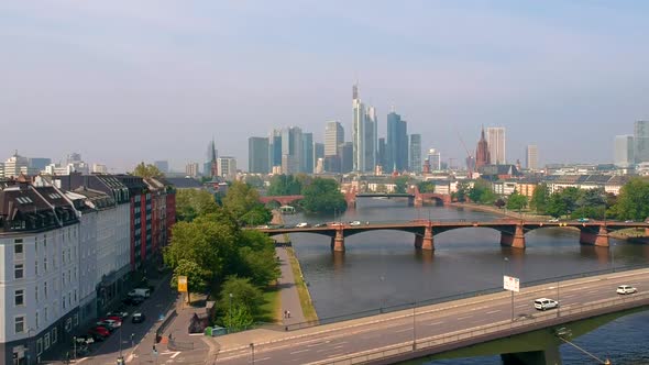 View Of Frankfurt City Skyline By The Main River With Daytime Traffic On Road Bridges In Frankfurt,