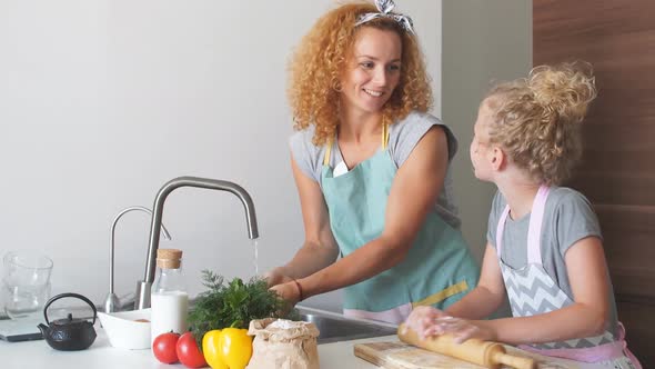 Woman and Cute Daughter Cooking on Kitchen, Making Dough for Birthday Party.