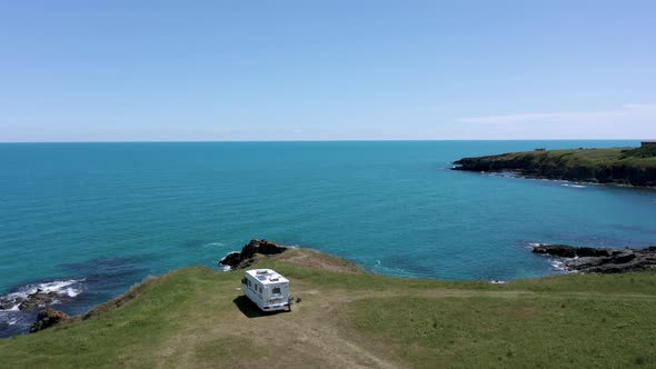 Drone flight above a picturesque coastline with camper car