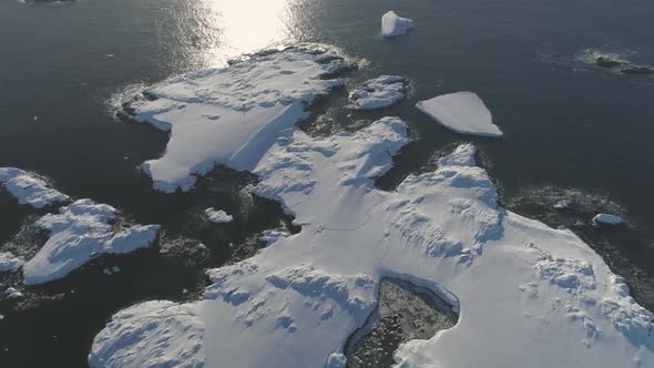 Aerial View To Antarctic Ocean Surface and Snow-covered Islands