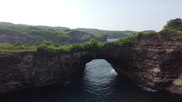 Beautiful Bali destination, scenery natural pool in form crater with a picturesque stone bridge over