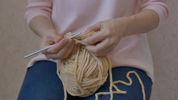 Woman Crochets Using Thick Beige Woolen Threads