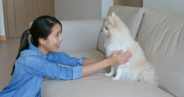 Woman cuddle her pomeranian at home