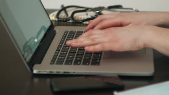 Woman Sitting at Desk and Connecting with Her Laptop She is Working and Typing on the Keyboard Hands