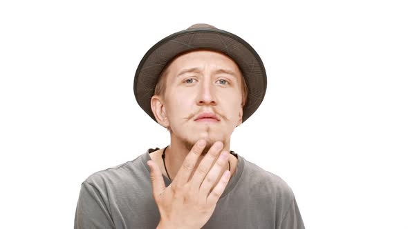 Young Handsome Man in Hat Careing Face Smiling Over White Background