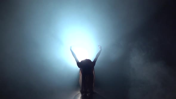 Slow Motion of Woman Dancing Contemporary in Dark Studio Against Spotlight.